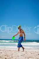 attractive man playing frisby on beach in summer
