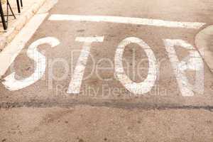 stop painted on asphalt outdoor
