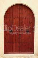 Arched wooden door in a stone wall