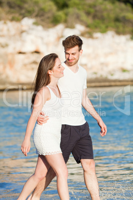 young happy couple walking on beach sunset holiday