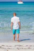 young man walking on the beach in holiday