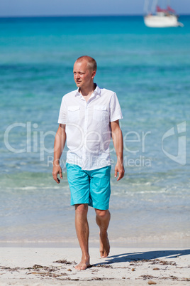 young man walking on the beach in holiday
