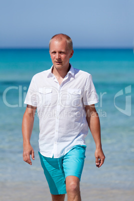 young man walking on the beach in holiday