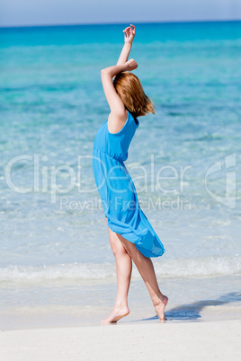 beautiful woman in blue dress on beach in summer