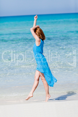 beautiful woman in blue dress on beach in summer