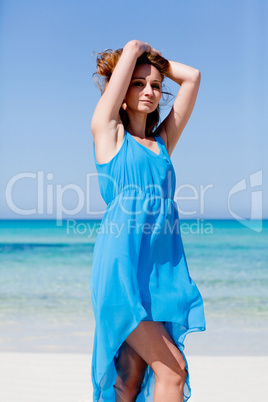 beautiful woman in blue dress on beach in summer