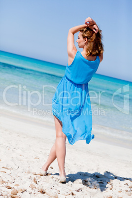 beautiful woman in blue dress on beach in summer