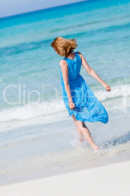 beautiful woman in blue dress on beach in summer