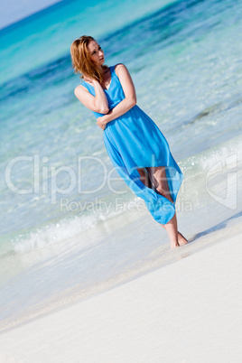 beautiful woman in blue dress on beach in summer