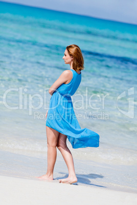 beautiful woman in blue dress on beach in summer