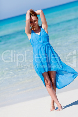 beautiful woman in blue dress on beach in summer