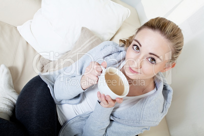 beautiful woman relaxing on couch with cup of coffe