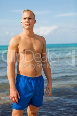 Man in blue swim shorts in the beach