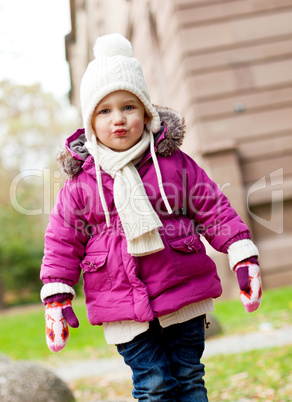 cute little child in pink jacket and hat outdoor