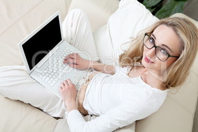 young blonde woman on couch with notebook