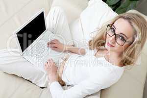 young blonde woman on couch with notebook
