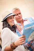 young attractive tourist couple with city map in summer