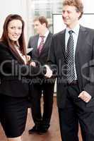 business woman and man shake hands in office