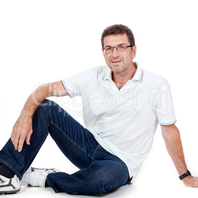 attractive healthy adult man sitting on floor with jeans isolated