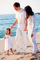 happy young family with daughter on beach in summer