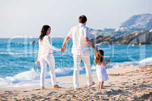 happy young family with daughter on beach in summer