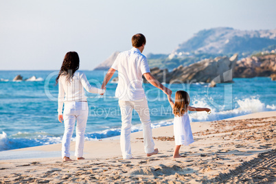 happy young family with daughter on beach in summer