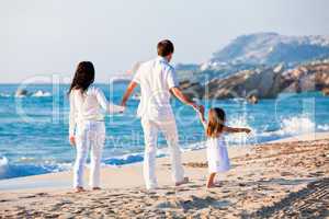 happy young family with daughter on beach in summer