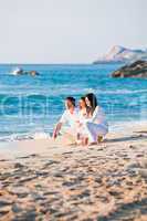 happy young family with daughter on beach in summer