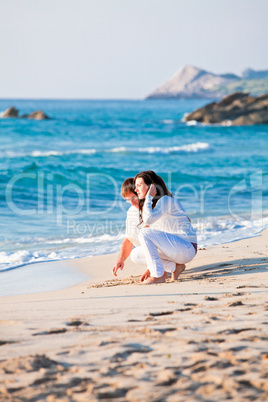 happy young family with daughter on beach in summer