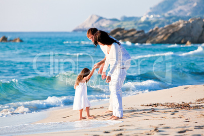 happy young family with daughter on beach in summer happy young family with daughter on beach in summer