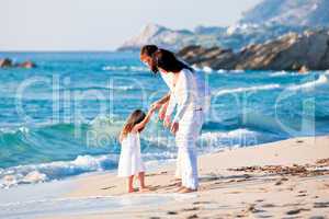 happy young family with daughter on beach in summer