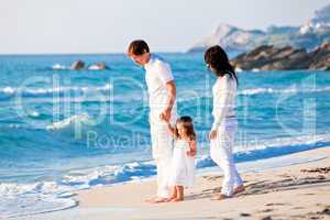 happy young family with daughter on beach in summer