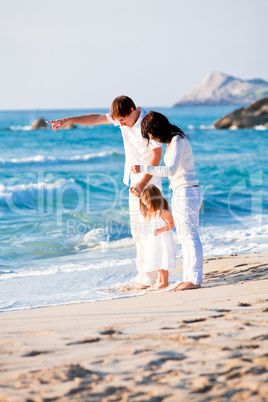 happy young family with daughter on beach in summer