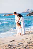 happy young family with daughter on beach in summer