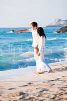 happy young family with daughter on beach in summer