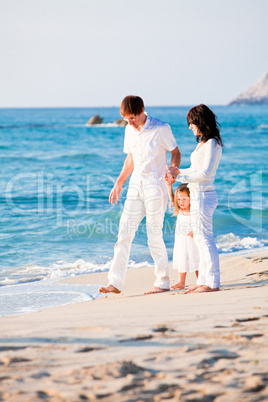 happy young family with daughter on beach in summer