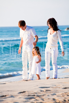 happy young family with daughter on beach in summer