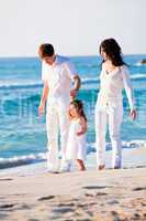 happy young family with daughter on beach in summer