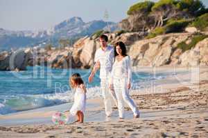 happy young family with daughter on beach in summer