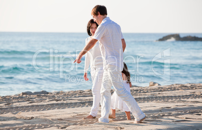 happy young family with daughter on beach in summer