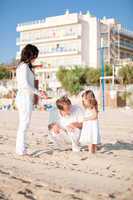 happy young family with daughter on beach in summer