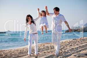 happy young family with daughter on beach in summer