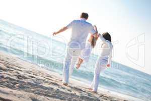 happy young family with daughter on beach in summer