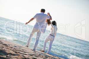 happy young family with daughter on beach in summer