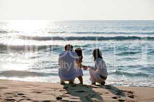 happy young family with daughter on beach in summer