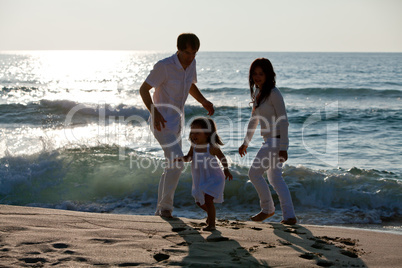 happy young family with daughter on beach in summer