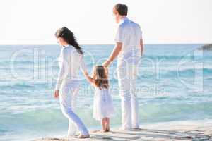 happy young family with daughter on beach in summer