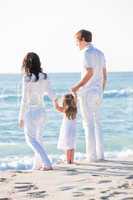 happy young family with daughter on beach in summer