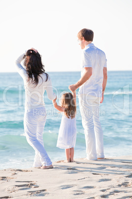 happy young family with daughter on beach in summer