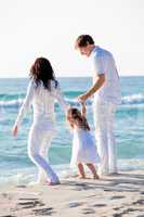 happy young family with daughter on beach in summer